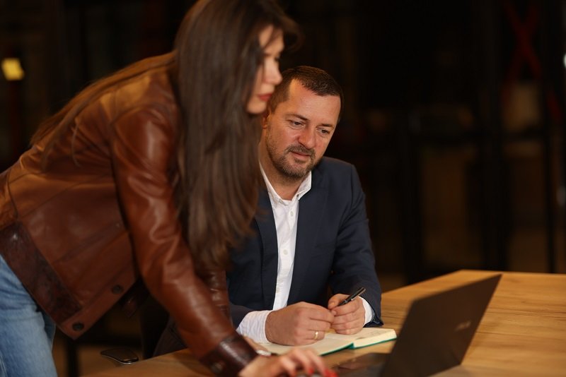 Professional colleagues collaborating over a laptop in a modern office